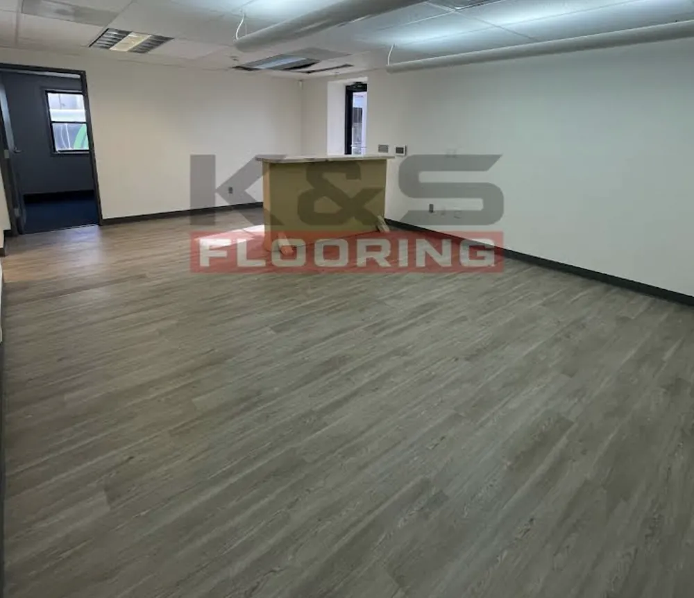 Open office-style room with a new gray plank floor