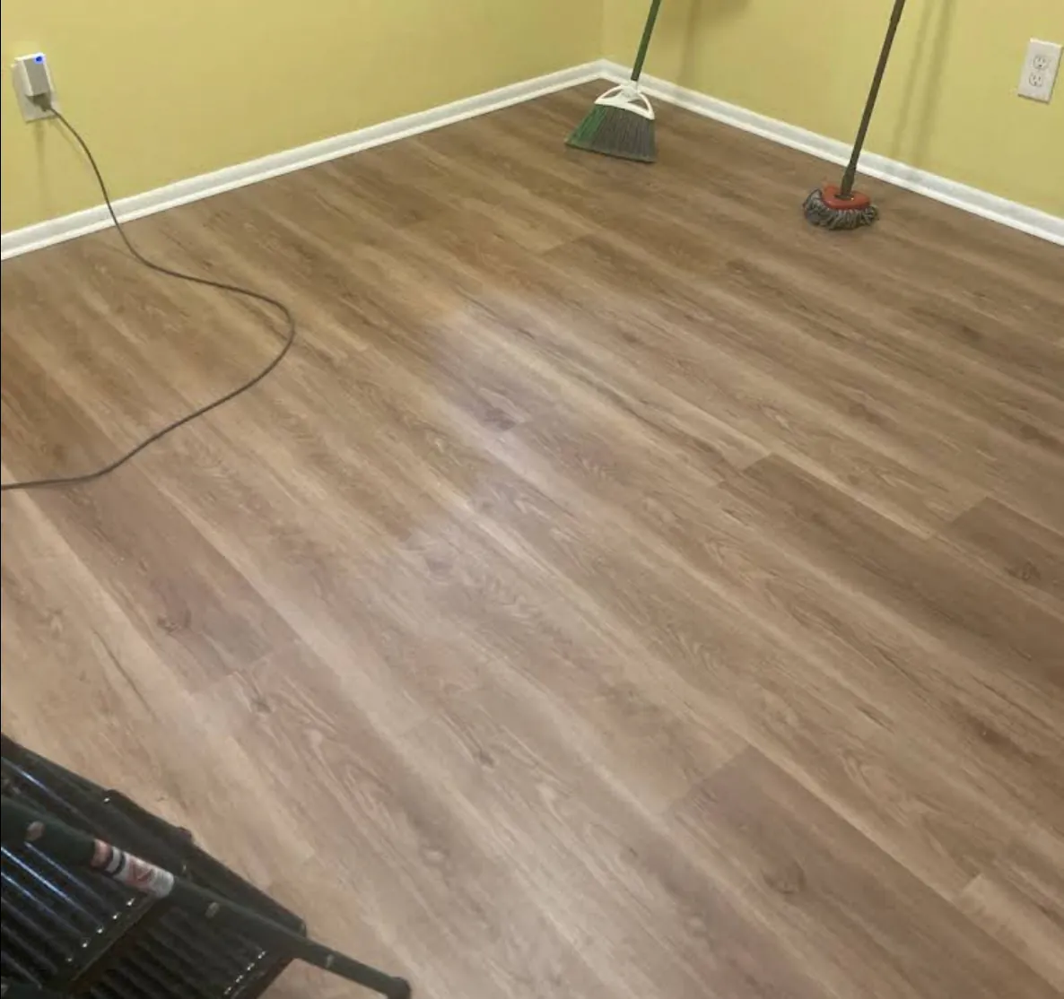 Empty room with yellow walls and newly laid light brown plank flooring