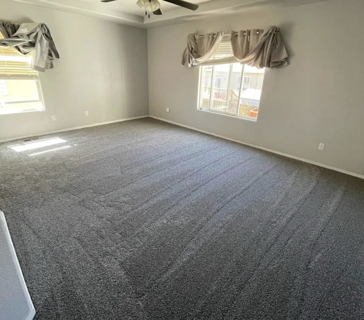 Living room with new charcoal carpet and window valances