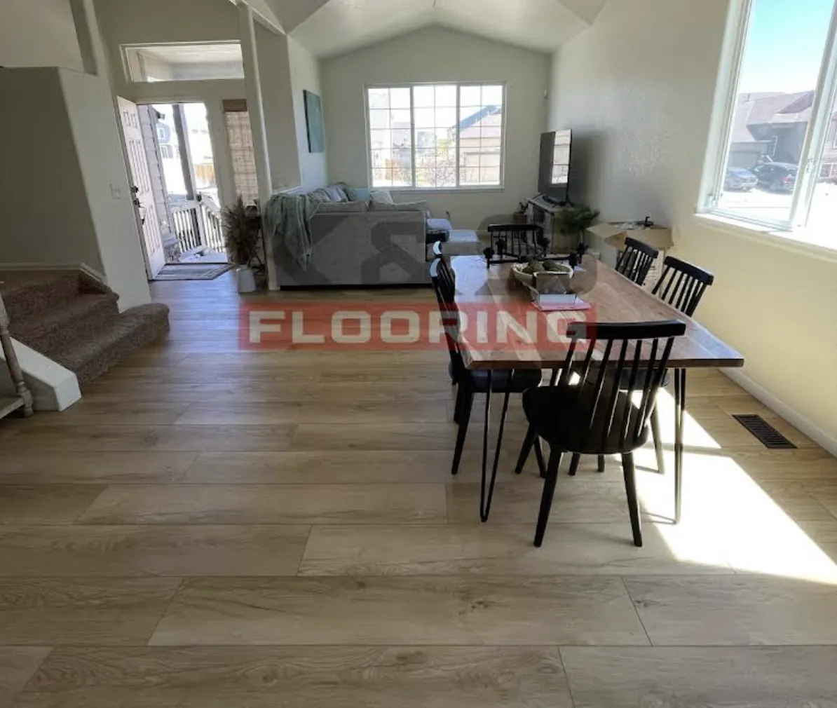 Dining room with a wood table and newly installed plank flooring in daylight