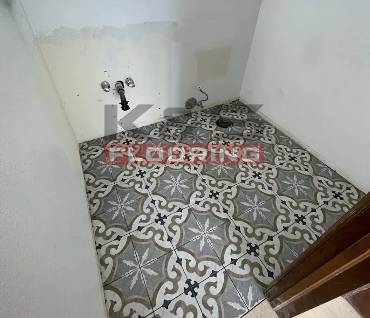 Bathroom floor tiled in a gray and white patterned tile